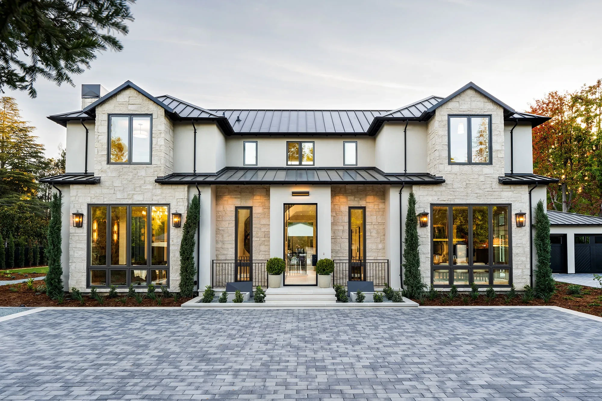 Shearer by GHG Builders — stone and stucco front elevation at dusk